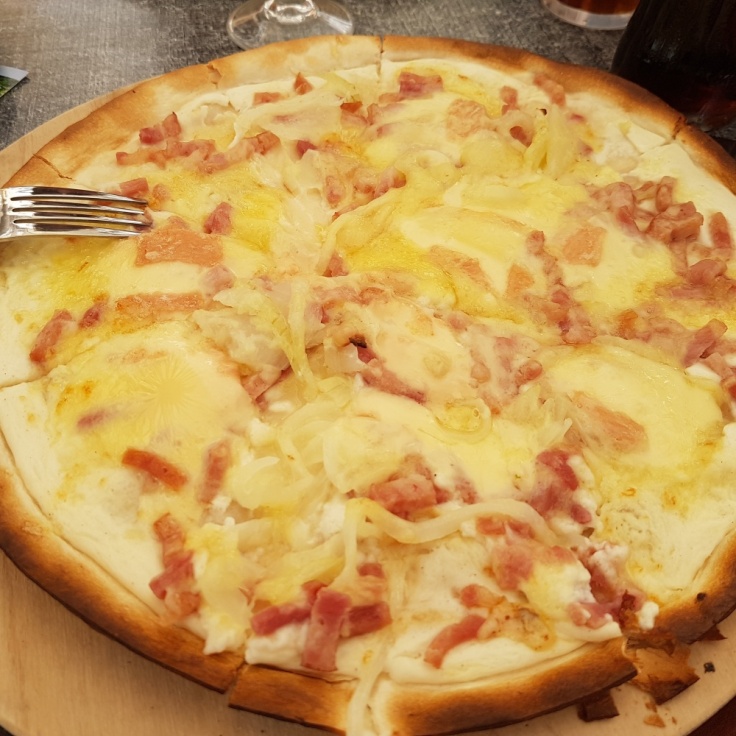 A tarte flambee with onions, cheese and bacon, an Alsatian speciality