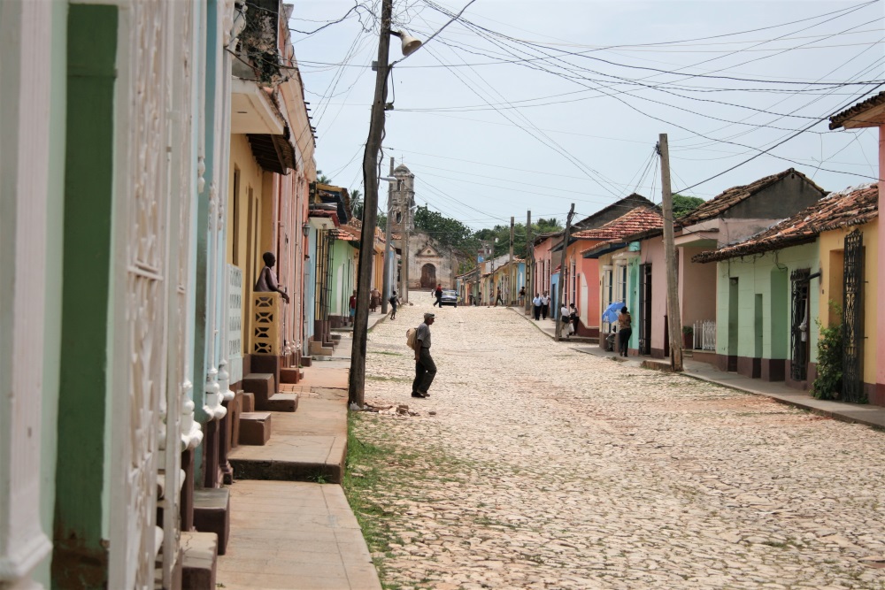 A man crosses a cobbled street in Trinidad, Cuba