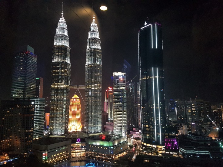 The twin Petronas Towers lit up at night in Kuala Lumpur, Malaysia